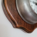 Wanduhr, Taschenuhr aus Holz und Zinn. Nahansicht Kratzer