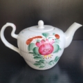 Teekanne, weiß, mit Blumendekor in pink, grün und orange. Ansicht Henkel links