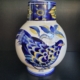 Vase, weiß, bauchig, mit schmalerem Hals. Blau gelbes Dekor und Fasan