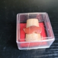 Fingerhut aus Holz, mit rotem Holzschuh. Ansicht in der Box