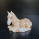 Liegendes Pferd in hellbeige und weiß