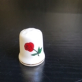 Fingerhut, weiß, mit Landumriss in rot, grün und weiß. Rückseite mit Rose