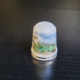 Fingerhut, weiß, mit Goldrand und einer Landschaftszeichnung mit Mühle