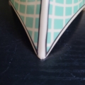 Eierbecher, 3-eckige Form, cremeweiß, mit türkisem Gitter Design. Nahansicht Chip