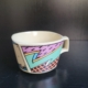 Tasse, eckig-rund, cremeweiß, mit 3 eckig bunten Motiven außen
