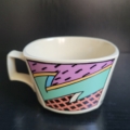 Tasse, eckig-rund, cremeweiß, mit 3 eckig bunten Motiven außen