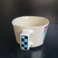 Tasse, eckig-rund, cremeweiß, mit 3 eckig bunten Motiven außen