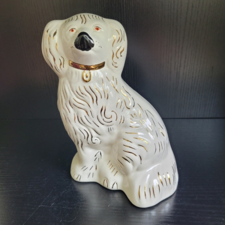 Hund, sitzend, weiß, mit goldenem Halsband und Applikationen, schwarzer Nase und roten Augen