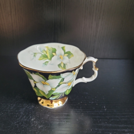 Kaffeetasse, weiß, außen schwarz, mit Goldrändern und weißen Blüten
