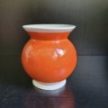 Vase, Kugelförmig, weiß, außen orange, mit handbemaltem Blumendekor in schwarz weiß. Rückseite ohne Dekor