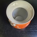Vase, Kugelförmig, weiß, außen orange, mit handbemaltem Blumendekor in schwarz weiß. Innenansicht